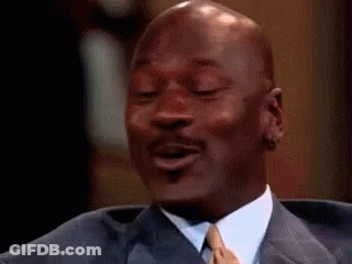 Michael Jordan Is Wearing A Suit And Tie And Smiling While Sitting In A Chair . GIF