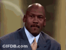 Michael Jordan Is Wearing A Suit And Tie While Talking On A Television Show . GIF