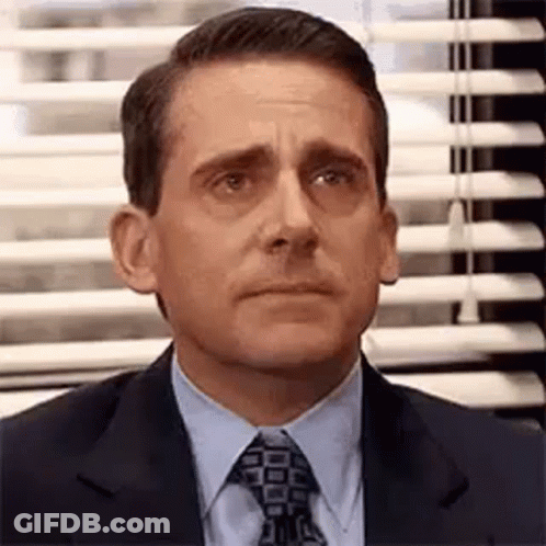 Michael Scott From The Office Is Wearing A Suit And Tie And Making A Funny Face . GIF