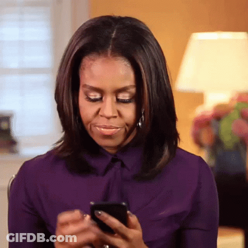 Michelle Obama In Purple Shirt Looking At Phone GIF