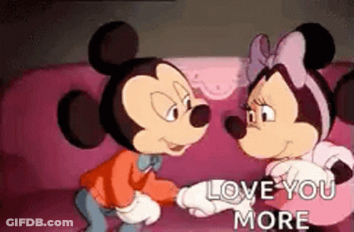 Mickey Mouse And Minnie Mouse Are Sitting On A Pink Couch Holding Hands And Looking At Each Other . GIF