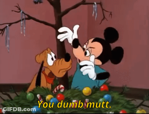 Mickey Mouse And Pluto Are Decorating A Christmas Tree And Mickey Is Saying You Dumb Mutt GIF