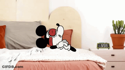 Mickey Mouse Is Laying On A Bed Next To A Clock That Says 5:59 GIF