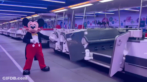 Mickey Mouse Mascot In Front Of Train GIF