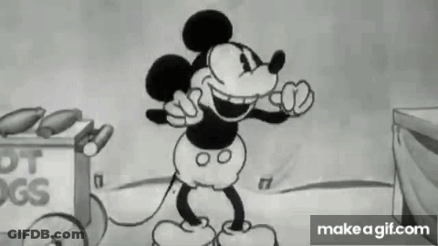 Mickey Mouse Standing In Front Of Hot Dog Cart GIF