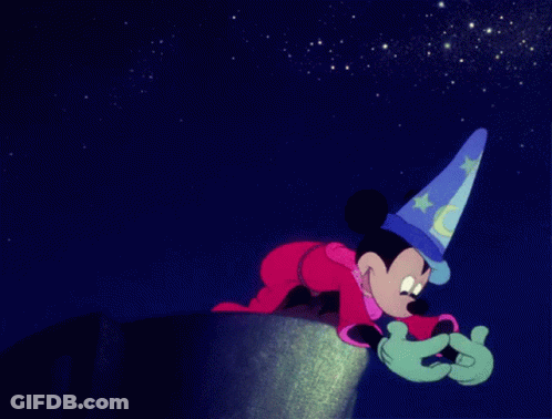 Mickey Mouse Wearing A Wizard Hat Is Crawling On A Cliff GIF