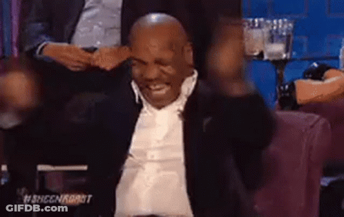 Mike Tyson Is Sitting In A Chair With His Arms In The Air And Smiling . GIF
