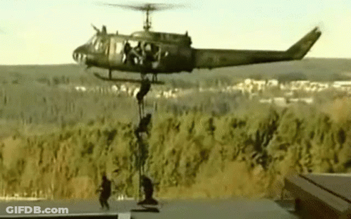 Military Helicopter With Soldiers Hanging From Side GIF