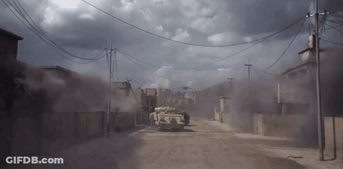 Military Vehicle Driving On Dirt Road Under Cloudy Sky GIF