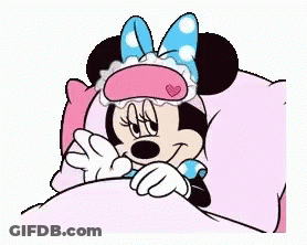 Minnie Mouse Is Sleeping In A Bed With A Sleep Mask On Her Face . GIF