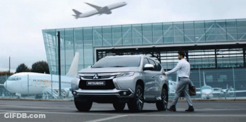 Mitsubishi SUV With Airplane Flying Overhead GIF