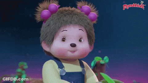 Monchhichi Doll In Yellow Shirt And Overalls With Purple Flowers GIF