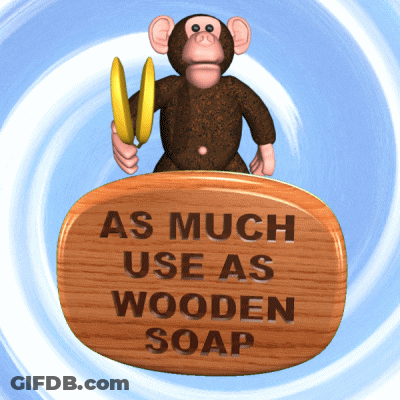 Monkey Holding Banana On Wooden Sign As Much Use As Wooden Soap GIF