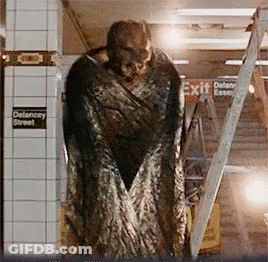 Monster Statue In Front Of Exit Sign GIF