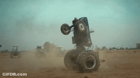Monster Truck Doing Trick On Dirt Road GIF