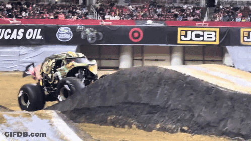 Monster Truck Driving Down Dirt Track In Front Of JCB Sign GIF