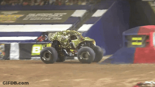 Monster Truck Driving Down Dirt Track Past Sign Saying B GIF