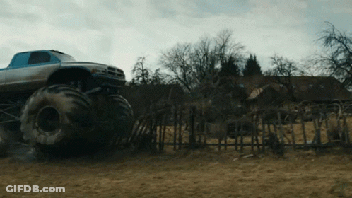 Monster Truck In Field Near Fence GIF