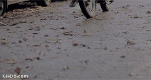 Motorcycle Driving Down Road With Car Behind GIF