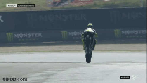 Motorcycle Racer Doing Trick On Track With Monster Energy Signs GIF
