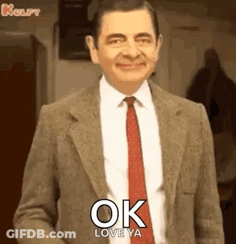 Mr Bean In Suit And Tie Smiling Saying Ok Love Ya GIF