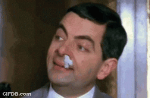 Mr Bean Is Holding A Napkin In His Nose And Smiling . GIF