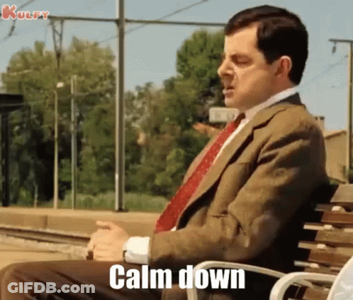 Mr Bean Is Sitting On A Bench With The Words `` Calm Down '' Written On It . GIF