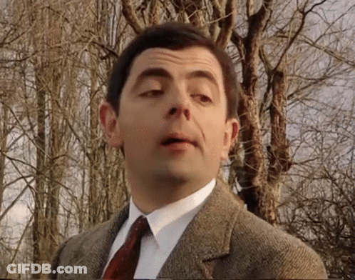 Mr Bean Is Wearing A Suit And Tie And Making A Funny Face . GIF