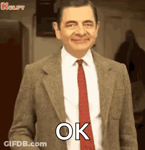 Mr Bean Is Wearing A Suit And Tie And Smiling While Saying Ok . GIF