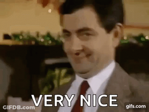 Mr Bean Is Wearing A Suit And Tie And Smiling While Saying `` Very Nice '' . GIF