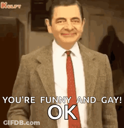 Mr Bean Is Wearing A Suit And Tie And Smiling While Saying `` You 'Re Funny And Gay Ok '' . GIF