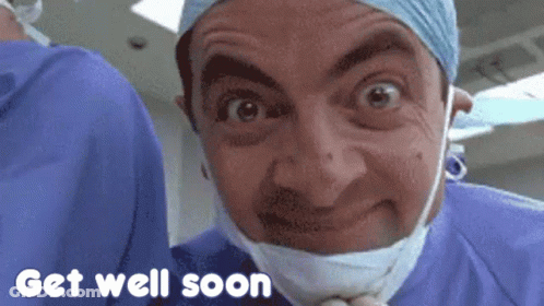 Mr Bean Is Wearing A Surgical Mask And A Surgical Gown And Says Get Well Soon GIF
