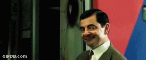 Mr Bean Smiling By Red And Blue Wall GIF