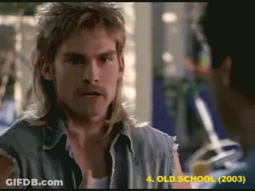 Mullet Man Talking To Another In Old School Movie GIF