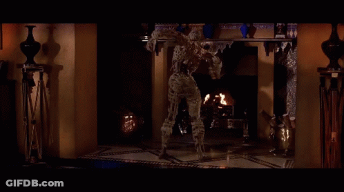 Mummy In Front Of Shelf With Vases GIF