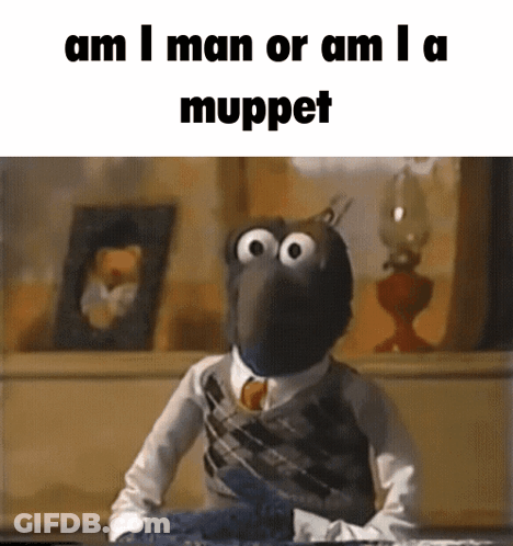 Muppet In Suit And Tie Sitting At Table GIF