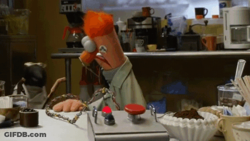 Muppet Sitting At Table With Red Button GIF