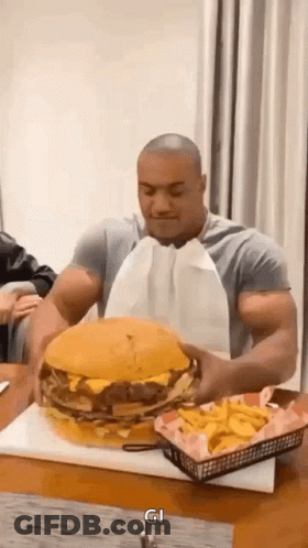 Muscular Man Eating Large Hamburger And Fries GIF