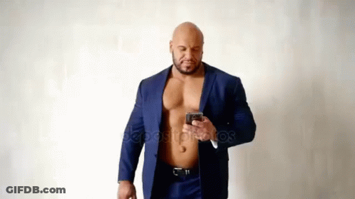Muscular Man In Suit Without Shirt Using Cell Phone GIF