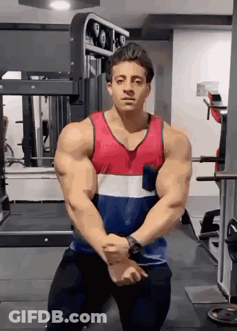 Muscular Man Kneeling In Gym With Hands Folded GIF