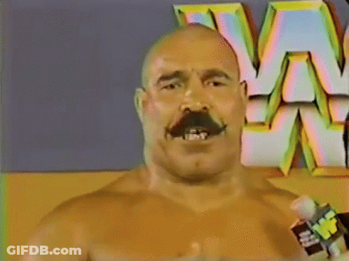 Mustached Man Holding Microphone In Front Of W Logo GIF