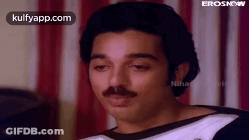 Mustached Man Sitting Before Striped Curtain GIF