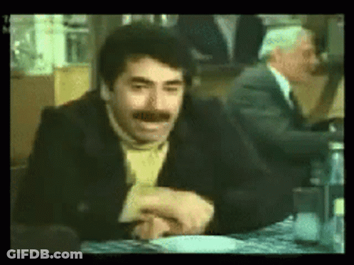 Mustached Man Sitting With Another At Table GIF