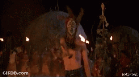 Naked Woman Standing In Front Of Fire In Dark Room GIF