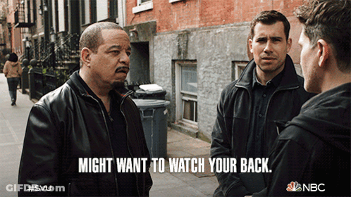 NBC Ad Three Men Talking On Street Saying Might Want To Watch Your Back GIF