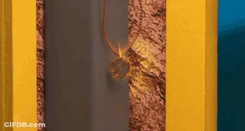 Necklace With Ring Hanging From Yellow Wall GIF