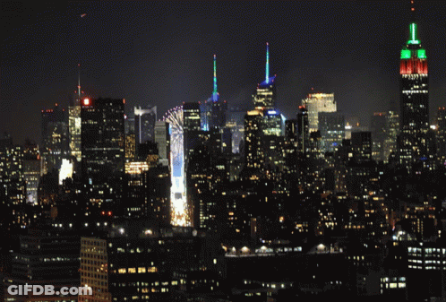 New York City Skyline At Night With The Empire State Building Lit Up GIF