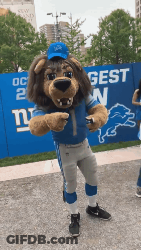 New York Giants Mascot In Front Of Blue Fence GIF