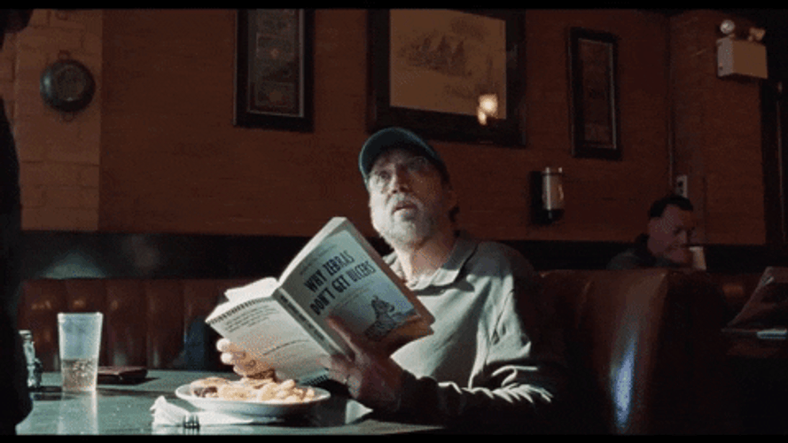 Nic Cage Reading Book In Diner GIF