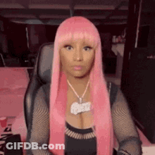 Nicki Minaj In Pink Wig And Necklace Sitting In Chair GIF